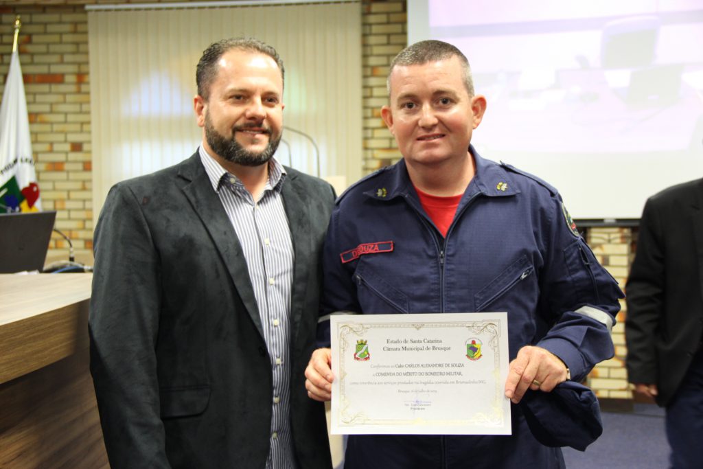 Carlos Alexandre de Souza, do Corpo de Bombeiros, recebendo comenda na Cãmara (Foto: Câmara)