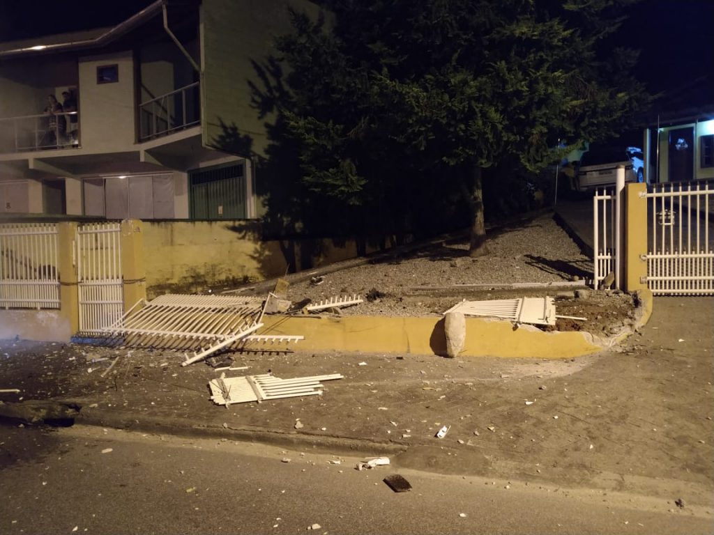 Carro bate em muro de residência e pega fogo