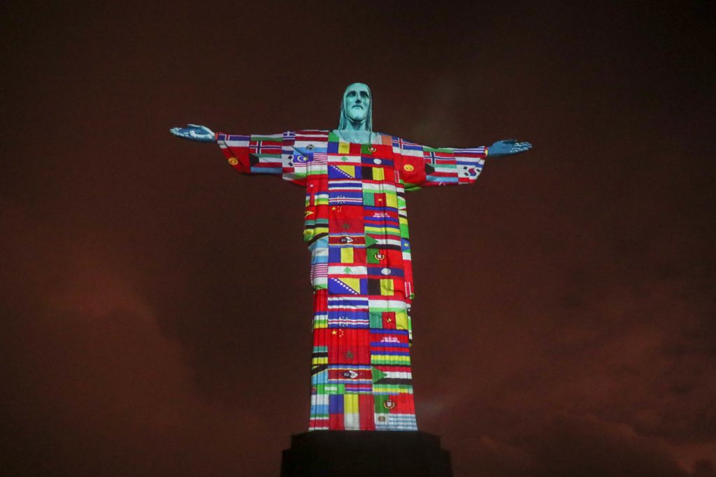 Cristo Redentor é iluminado com bandeiras de países