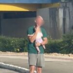 Rafael segura a filha no colo, durante assalto em Brusque,